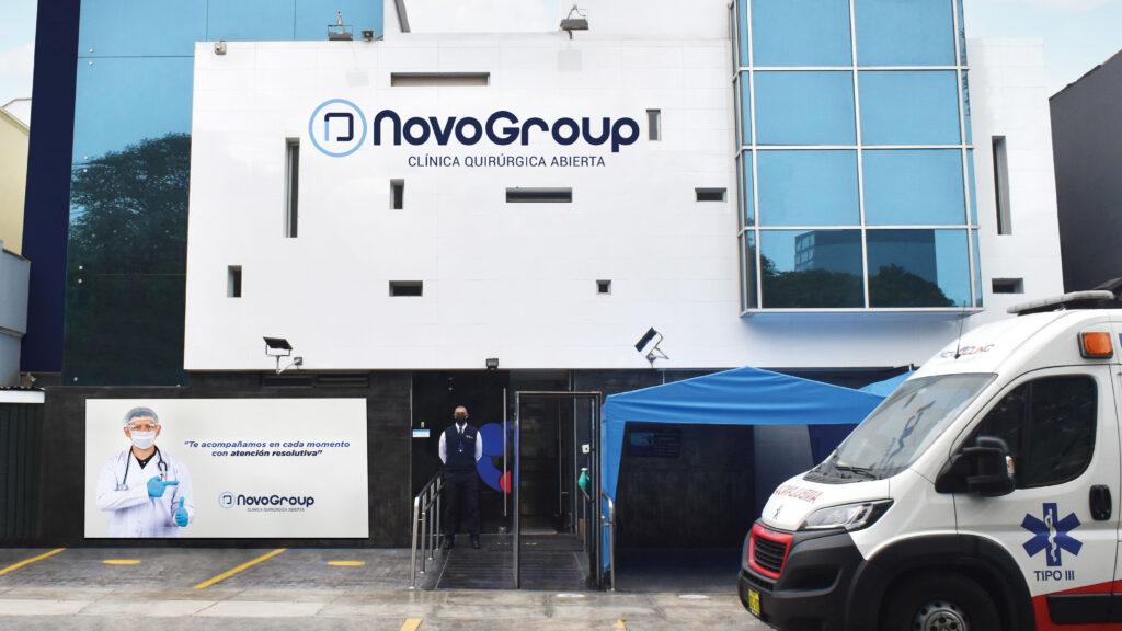 Fachada de la clínica quirúrgica abierta NovoGroup en San Isidro, Lima, con ambulancia estacionada afuera.